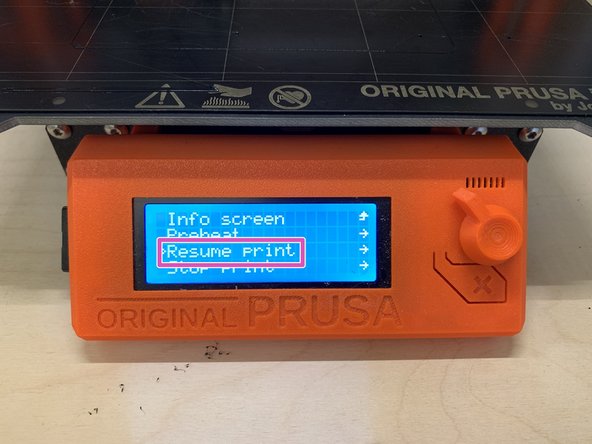 The printer will stop printing and move the extruder away from the print area.