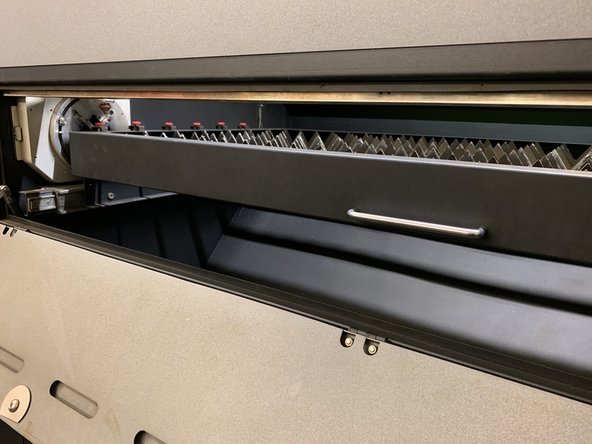 Grab the handle of the front door of the machine and gently pull it open.  It will fold downward.