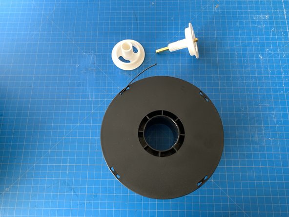 Grasp the hub going through the middle of the reel and unscrew it.  It may be a little stiff but it will thread off.