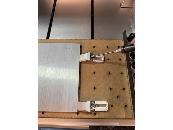 på bildet ser vi en aluminiumsplate som er festet med L braketten og to klemmer, her str begge klemmene langs en kant, dette er ikke ideelt men er nødvendig her grunnet størrelsen på plata