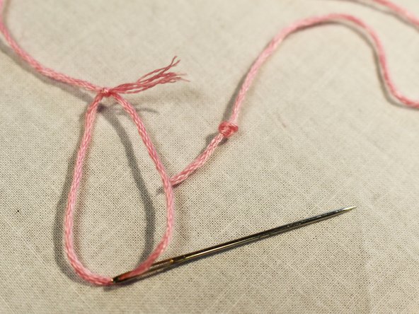 Pull the thread through the eye of the needle and tie the thread in a knot