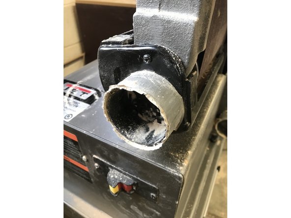 There is a single screw on the dust port. Remove this to slide it off the machine.