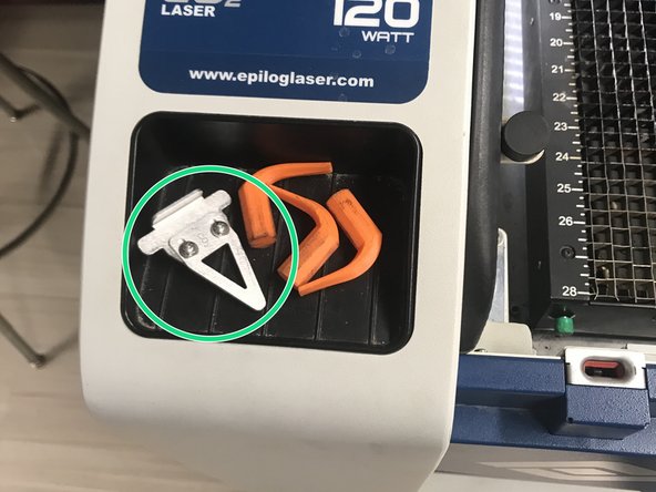 Find the focus tool on the left side of the laser.