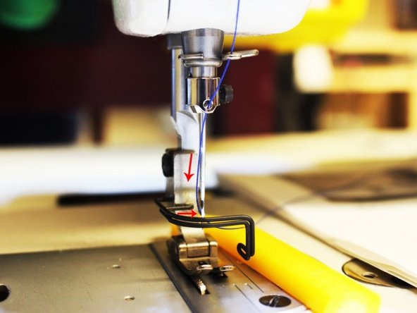 Then, keep pulling the thread down to the needle hold and pull the thread through the needle hole from left to right and the thread should circle the needle shaft.