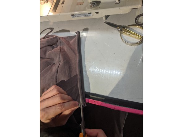 Stretch out one of the sleeves and cut a strip about 1/4 inch thick.