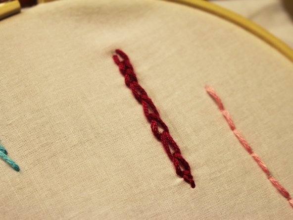 Bring the needle and thread up through the back of the fabric