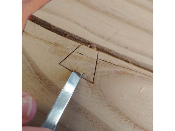 Drop the chisel in near the center of the outside edge, rock it in place and bring it down to a shallow angle.