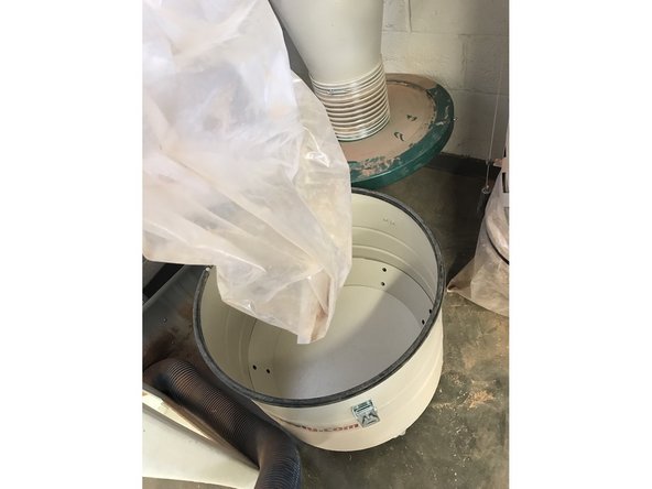 Remove the dust bag and empty in the trash, then put the bag back in the bin.