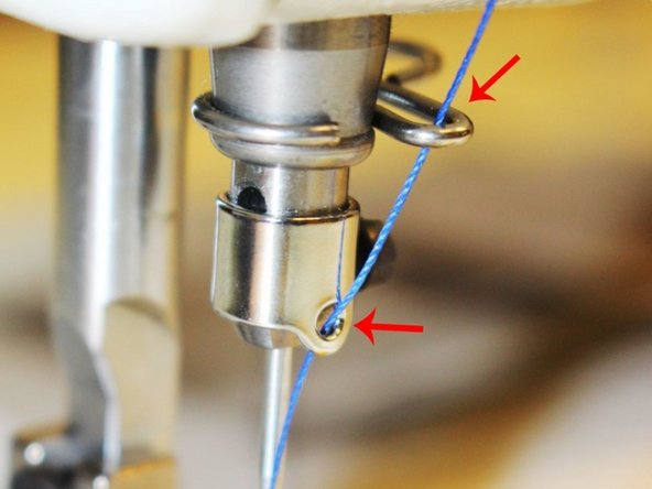 Down where the needle should be there is a small silver hook right above the needle. Bring the thread down and push the thread from top to the bottom through the hook.