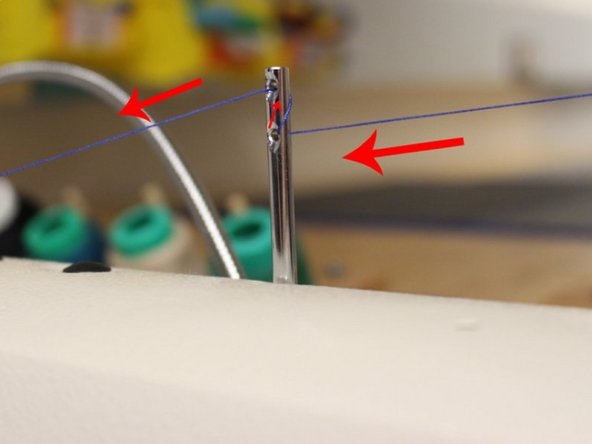The second thread holder is located at the front and also has two holes but is smaller. Pull the thread in the first step from the right to the left of the top hole of the holder. After, wrap the thread to the right side of the bottom hole and pull it through the left again.