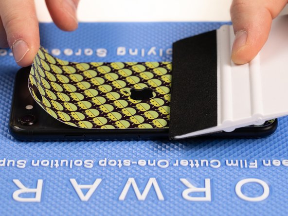 Use your application tool to hold the bottom of the back film down.