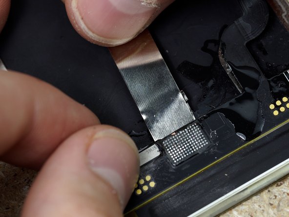 Wedge a small piece of metal underneath the Flex. We're doing this to keep the heat away from the OLED and avoid damage.