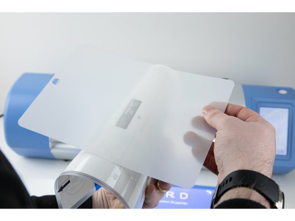 Slowly peel away each side of the film until they meet in the middle and you're able to peel the whole film off.