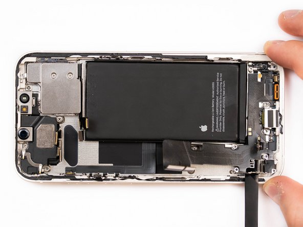 Begin prying the start of the charge port flex up with a spudger.