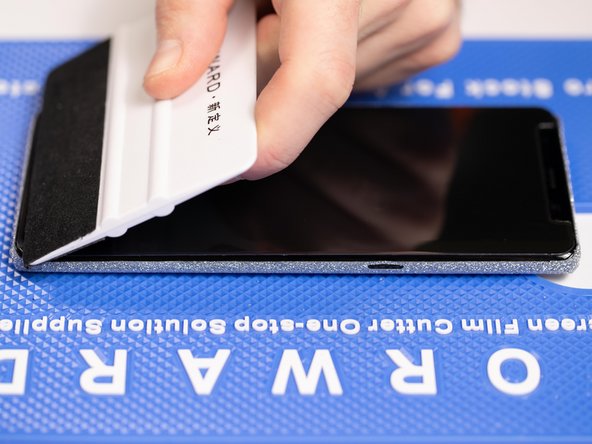 With your application tool slowly slide it along the film until you reach the end of the phone.