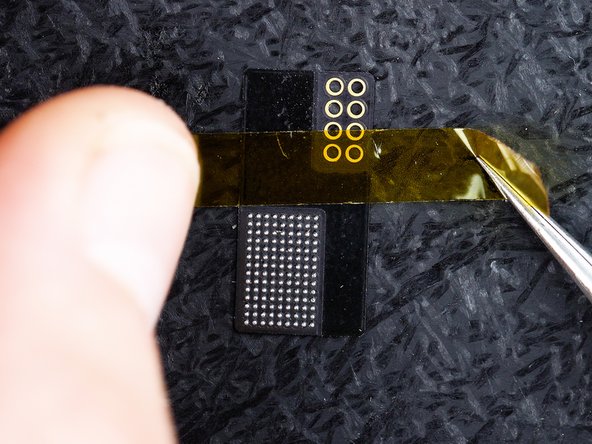 Put a piece of Kapton tape across the flex. This is just to prevent any movement in the flex in the next steps. Make sure you stick the flex to a heat resistant pad, We're using the Amaoe Screen IC Reball Stencil With Magnetic Base.