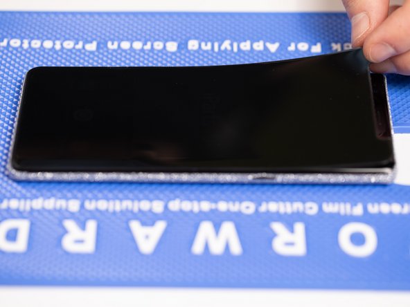 Peel the top of the front film backwards past the middle of the phone until the two layers split.