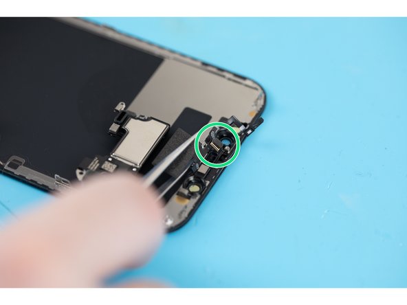 Using a pair of tweezers or a spudger, lift and separate the microphone from its pocket.