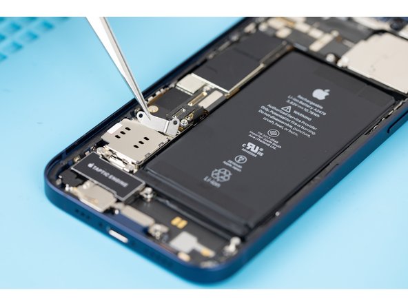 Using tweezers or your fingers, remove the Sim card reader cable connector cover.