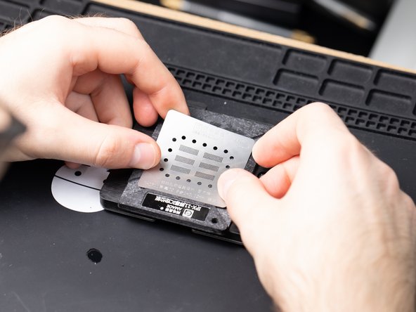 With your IC chip still resting on your platform, grab an iPhone 11 reballing stencil and wedge it on top of the platform.