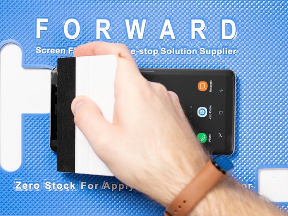 Run your application tool across the entire front film one last time to smoothe out any bubbles and ensure it's fully stuck down.