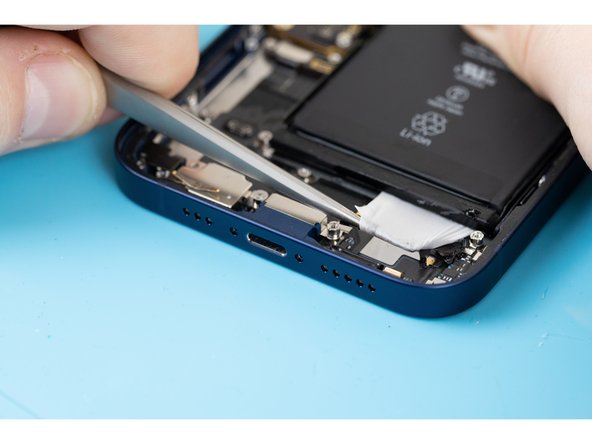 Using a tweezers, slowly pull the adhesive out from under the battery.