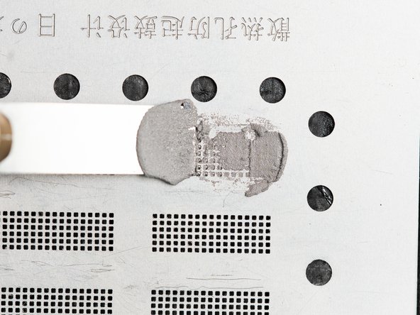 Rub the dried solder paste back and forth on top of the stencil to fill in all of the holes.
