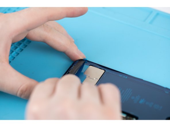 Use a spudger to firmly press the adhesive in place across all four corners.