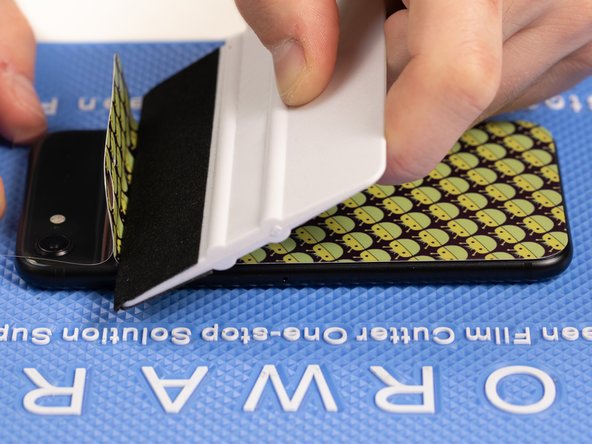 With your application tool slowly slide it along the film until you reach the top of the phone.