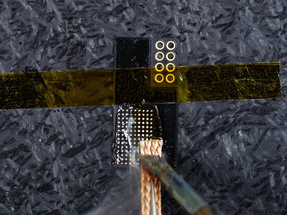 Rub the solder wick across the flex until the joints are flat.