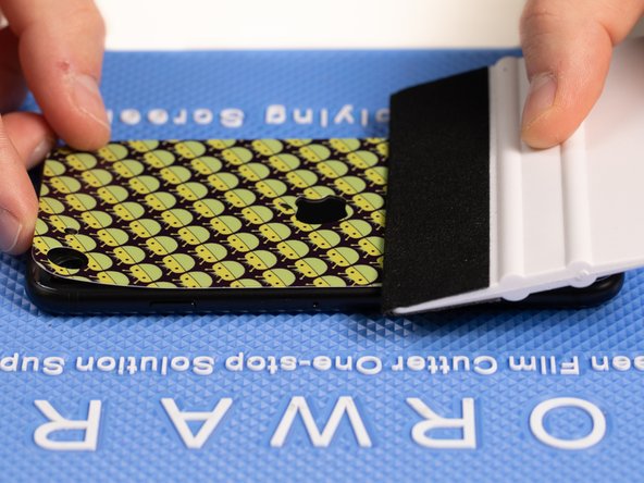 Peel the top of the back film backwards to the middle of the phone until the two sticky layers split.