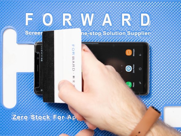 With your application tool slowly slide it along the film until you reach the top of the phone.