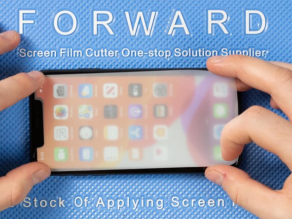 Lower the front film onto the front of the phone. We find it's easiest to lower the top end of the film first.