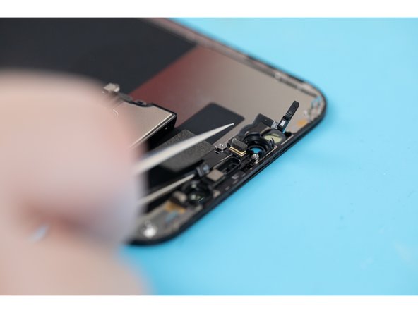 Using a pair of tweezers or a spudger, lift and separate the microphone from its pocket.