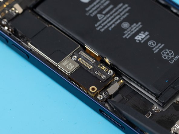 Using a spudger, slowly lift the motherboard out from between the frame and the battery.