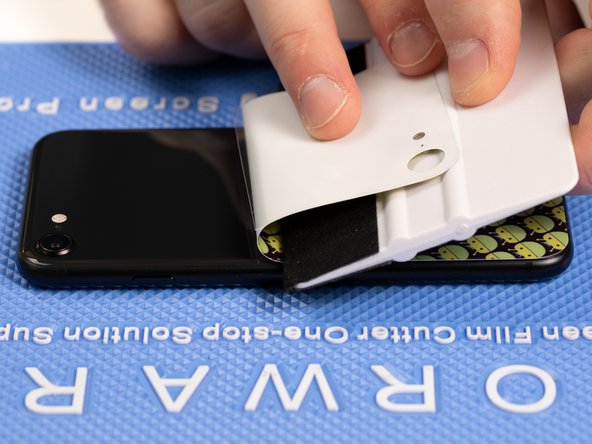 Use your application tool to hold the bottom of the back film down.