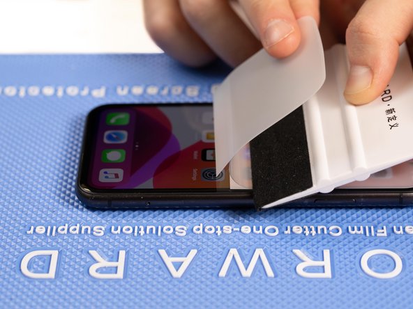With your application tool slowly slide it along the film until you reach the end of the phone.