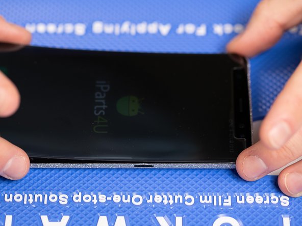 As you lower the film down onto the phone into the correct position, Use an application tool or brush your finger across the entire strip to help it attach to the phone.