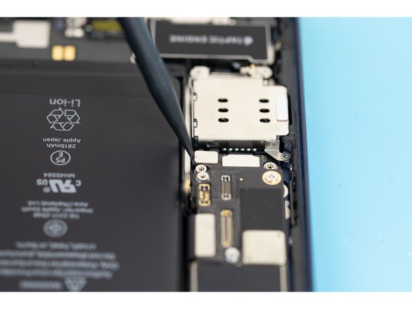 Using the tip of a spudger, pry the sim card reader flex out of its socket on the logic board.