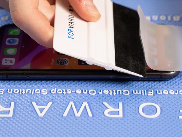 With your application tool slowly slide it along the film until you reach the top of the phone.