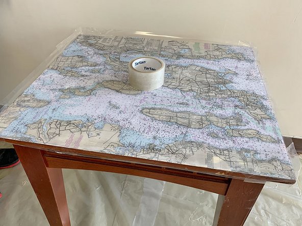 Form a dam by applying clear packing tape around the edges of the table. Make sure you have at least 1” of tape sticking up beyond the top edge of the table to contain the flood coat(s) of epoxy.