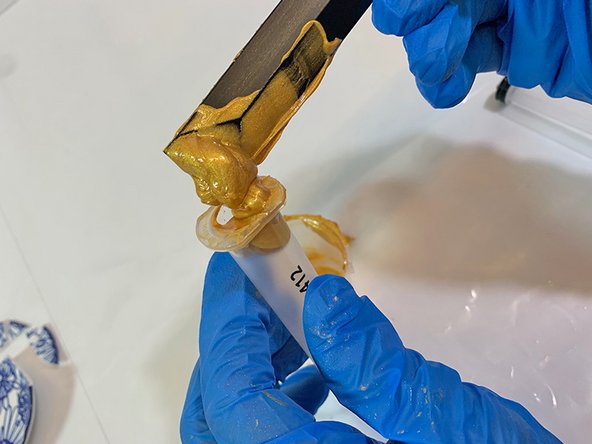 Use a mixing stick to scoop the gold pigmented epoxy into the syringe.