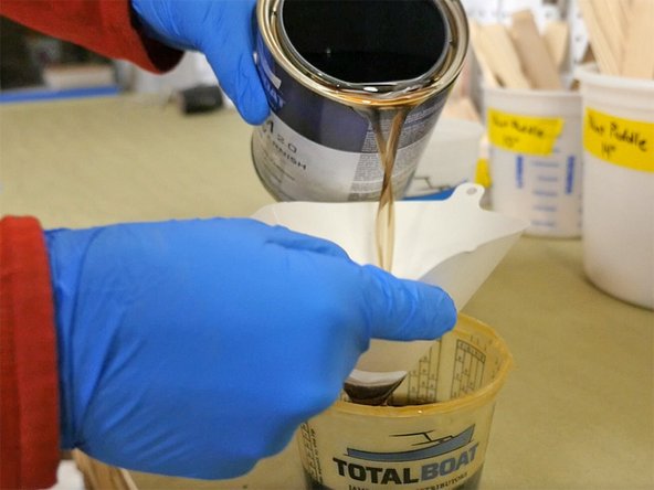 Filter the varnish by pouring it through a varnish strainer and into a separate, clean container. This will also prevent contamination of the varnish remaining in the can. Pour only the amount you'll use in any one application.