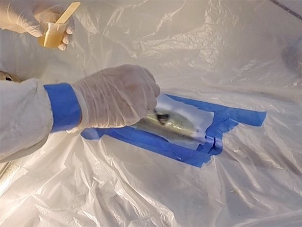 (Optional) If you have a small dry brush available, you can use it to help the peel ply stick to the epoxy completely (see second image).