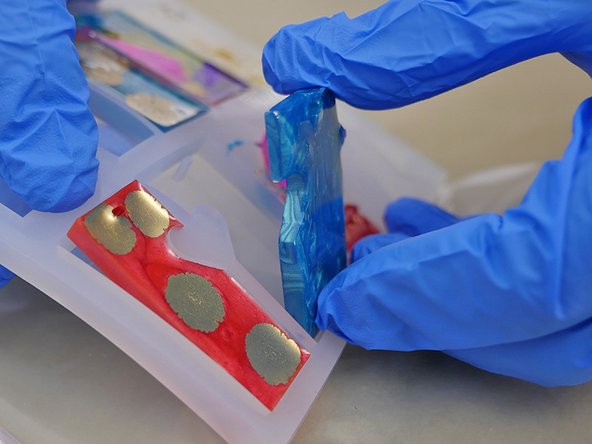 To remove the jewelry pieces from the mold, press firmly against the back side of the mold. The silicone molds provided in the TotalBoat Epoxy Jewelry Kit will create a glossy finish.