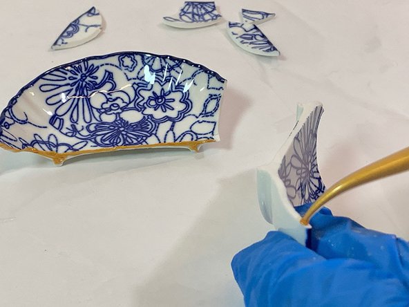 Squeeze a thin bead of epoxy onto each of these larger broken pieces.