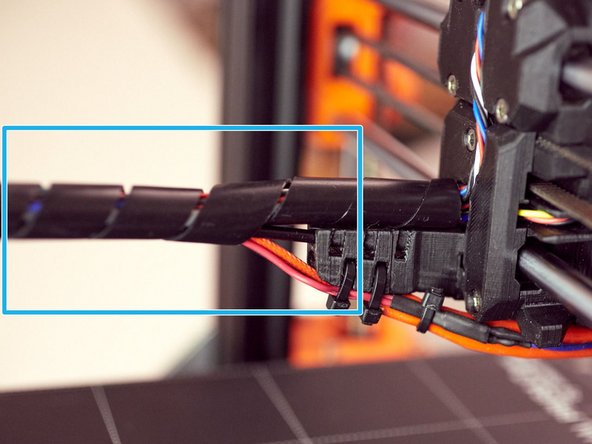 Continue spiral wrapping the cable now including the nylon filament and hotend cables.