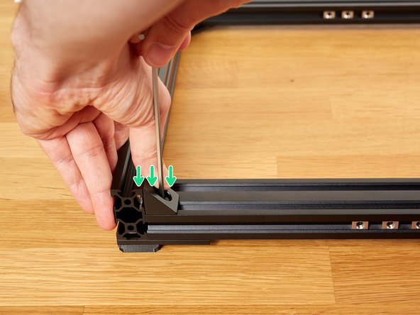 For each corner, tighten the two M5x8 screws, in turn, while applying pressure as shown in the images.