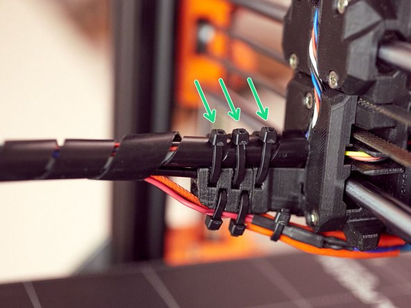 Secure the spiral wrap to the cable_guide_back using three zip ties.