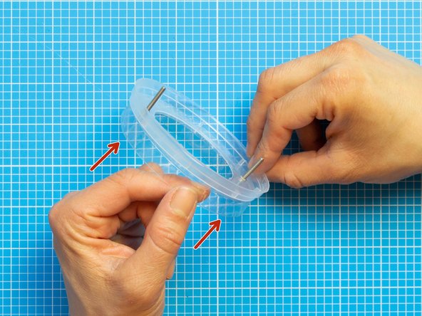 Hold the lids facing each other as shown in the picture.  Push the two screws provided in the fan kit starting from the bottom lid.